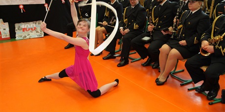 Powiększ grafikę: uczennica tańczy z szarfą, w tle orkiestra straży granicznej