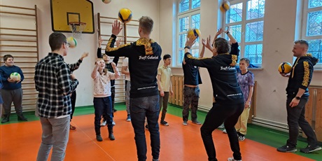 Powiększ grafikę: Uczniowie ćwiczą podbijanie piłki koszykowej z zawodnikami