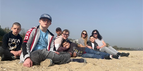 Powiększ grafikę: Grupa ludzi wypoczywająca na piaszczystej plaży w piękny, słoneczny dzień 