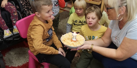 Powiększ grafikę: Przedszkolaki obchodzą urodziny - dmuchają w świeczkę na torcie