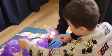 Powiększ grafikę: chłopiec siedzi przy stoliku I sprawdza w lusterkach ,kim będzie w przyszłości