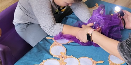 Powiększ grafikę: 8.	Chłopiec siedzi przy stoliku I sprawdza w lusterkach ,kim będzie w przyszłości.