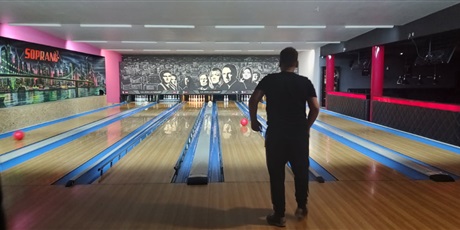 Powiększ grafikę: Widok z tyłu - rzut kulą do kręgli po torze.