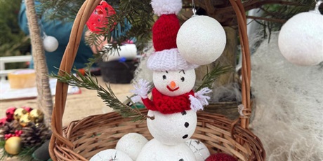 Powiększ grafikę: Bałwanek ze styropianowych kulek w koszyczku wiklinowym. Za nim żywa choinka. 