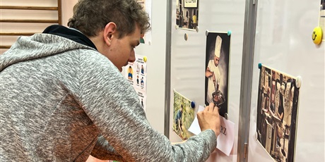 Powiększ grafikę: Uczeń przypinający etykietę z napisem pod ilustracją kucharza.