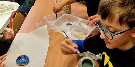 Powiększ grafikę: 4.	Chłopiec z mamą malują świecznik przy stoliku.