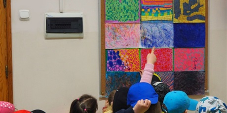 Powiększ grafikę: Uczniowie przyglądają się pracom plastycznym zawieszonym na tablicy ściennej