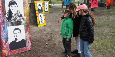 Powiększ grafikę: Uczniowie oglądają portrety wychowanków Ośrodka oparte o drzewa