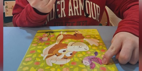 Powiększ grafikę: Kolaż 4 zdjęć uczniów, zbliżenia twarzy oraz widok na ławkę i układane puzzle wieloelementowe z bajek.