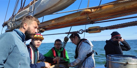Powiększ grafikę: Uczniowie na statku Generał Zaruski pracują przy linach. w tle morze.