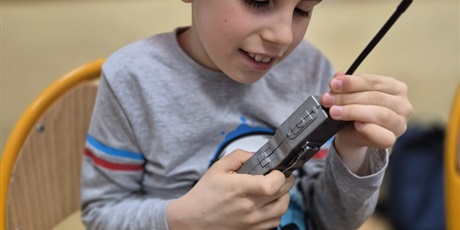 Powiększ grafikę: Chłopie w kasku strażackim rozmawia przez walkie talkie.