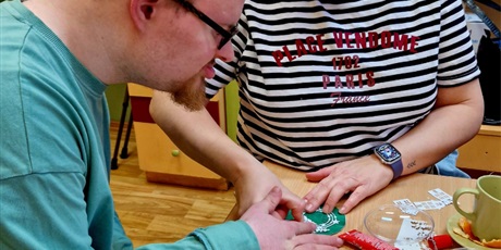 Powiększ grafikę: uczeń z mamą tworzą ozdobną papierową bombkę.