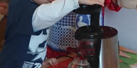 Powiększ grafikę: Pani i chopiec wrzucają do sokowirówki buraka i robią sok z buraka.