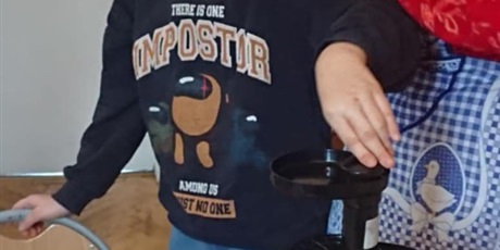 Powiększ grafikę: Chłopiec pod kontrolą pani uruchamia sokowirówkę.