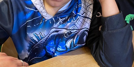 Powiększ grafikę: Chłopiec z pomocą pani nalewa sok z buraczka do plastikowego kubeczka.