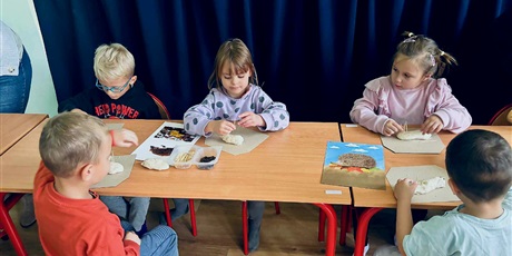 Powiększ grafikę: 3.	Dzieci siedzą przy stoliku, przed nimi leży obrazek jeża oraz materiały do wykonania jeża z masy solnej.