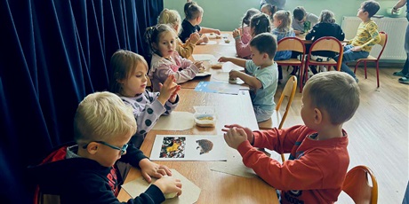 Powiększ grafikę: 10.	Dzieci siedzą przy stoliku I robią jeże z masy solnej.