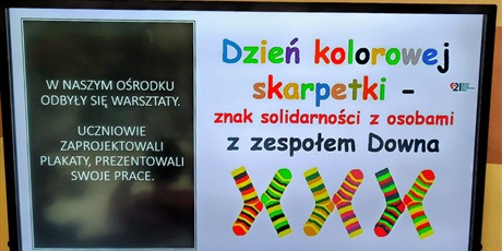 Powiększ grafikę: Tablica multimedialna z kolorowymi chromosomami oraz informacja Dzień kolorowej skarpetki- znak solidarności z osobami z zespołem Downa. Informacja o warsztatach.