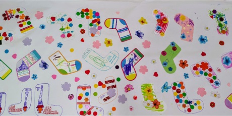 Powiększ grafikę: plakat z kolorowymi skarpetami zrobionymi podczas warsztatów.