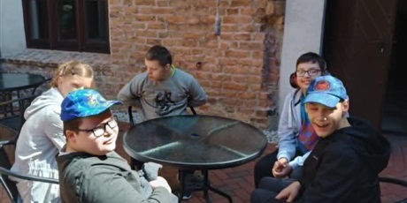 Powiększ grafikę: Grupa chłopców i dziewczynka siedzą przy stoliku w kawiarni