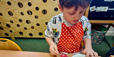 Powiększ grafikę: 5.	Chłopiec lukruje na czerwono swoje ciastka.