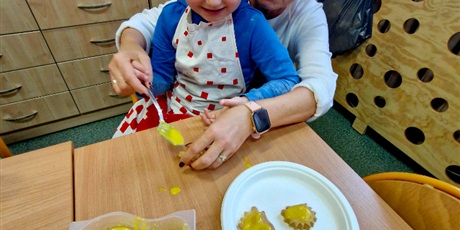 Powiększ grafikę: 2.	Nauczycielka pomaga chłopcu lukrować upieczone ciasteczka.